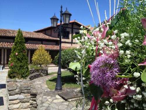a garden with flowers in front of a building at Hotel Palacio de Elorriaga in Vitoria-Gasteiz