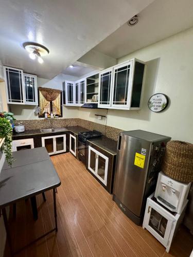 a kitchen with a stainless steel refrigerator and a table at M & D Rentals by Jick in Butuan