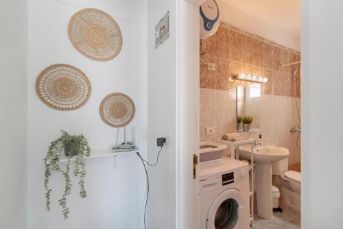 a bathroom with a washing machine and a toilet at Uga La Dehesa I in Uga