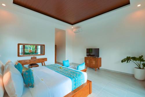 une chambre avec un grand lit et une télévision dans l'établissement Matahari Lumbung Resort, à Ubud