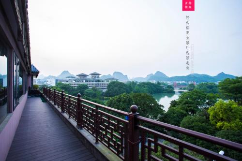 a balcony with a view of a river and mountains at Aroma Tea House Former Jing Guan Ming Lou Museum Hotel in Guilin