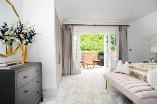 a white bedroom with a bed and a dresser at Luxury 3 Bed Penthouse with Large Terrace and Private Parking in Sunningdale