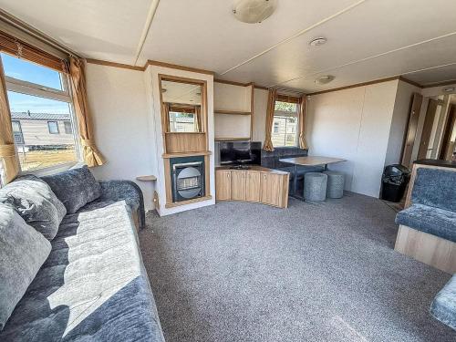 an rv living room with a couch and a tv at Homely Dog-Friendly Caravan At Valley Farm In Essex, Ref 46633V in Great Clacton