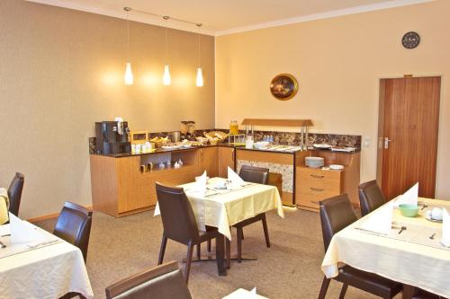 ヴァイル・アム・ラインにあるHotel Ganita Weil am Rheinのテーブルと椅子のあるレストラン、キッチンが備わります。