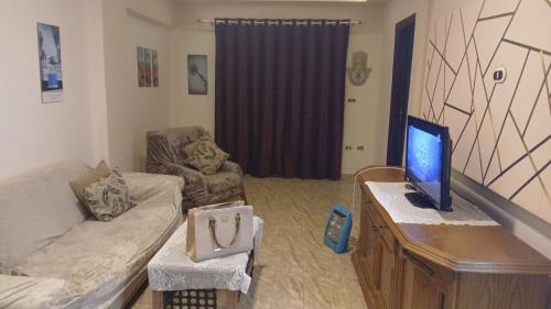 a living room with a couch and a television on a table at Flores casas de playa in Alexandria