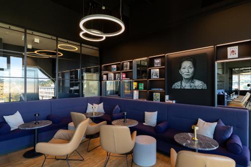 a restaurant with a blue couch and tables and chairs at Hotel am Remspark in Schwäbisch Gmünd