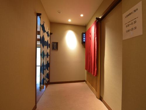 a hallway with a door and a flag on the wall at Kaihinsou Kamakura in Kamakura