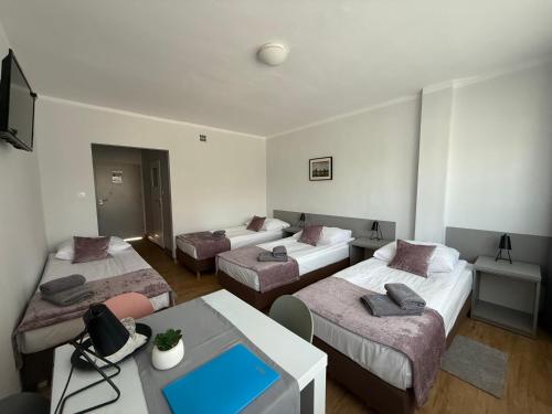 a hotel room with three beds and a table at Sport Hotel in Jelenia Góra