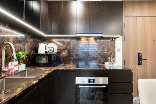 a kitchen with a sink and a stove at Lumiere Horizon Suites in Ho Chi Minh City