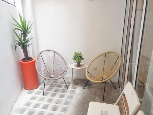 two chairs and a table with a potted plant at Dormavalencia Hostel in Valencia