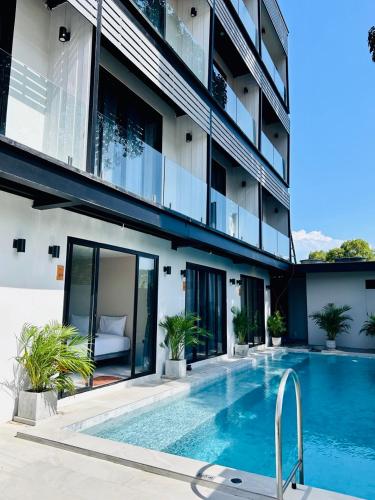 a hotel with a swimming pool in front of a building at The Villager Fishermans Village in Bophut