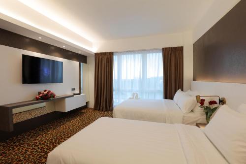 a hotel room with two beds and a flat screen tv at Amerin Hotel Johor Bahru in Johor Bahru