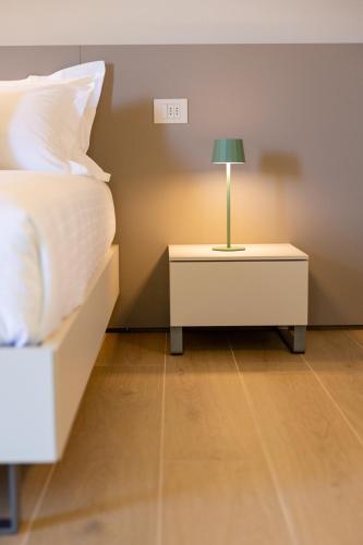 a bedroom with a bed and a lamp on a night stand at RESPIRA - rooms & apartments in Serralunga d'Alba