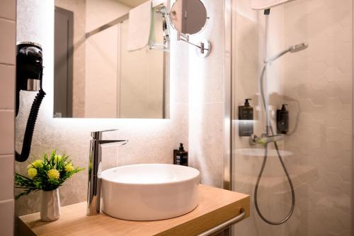 a bathroom with a sink and a shower at Mercure Alba Iulia in Alba Iulia