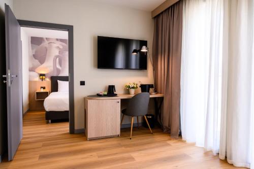 a hotel room with a desk and a bed at Mercure Alba Iulia in Alba Iulia