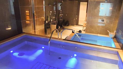 a bathroom with a tub with a shower and a sink at HOTEL LiVEMAX Honhachinohe Ekimae in Hachinohe