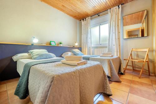 a bedroom with two beds and a chair and a window at Eremita in La Figuera