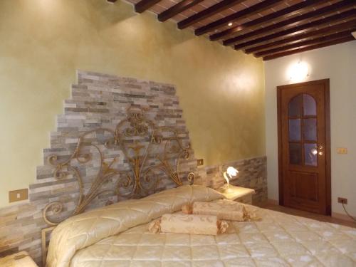 sypialnia z łóżkiem z kamienną ścianą w obiekcie Il Nido Rustico w mieście Ponsacco
