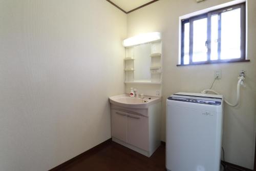 a small bathroom with a sink and a washing machine at 別荘五岳 in Minami Aso