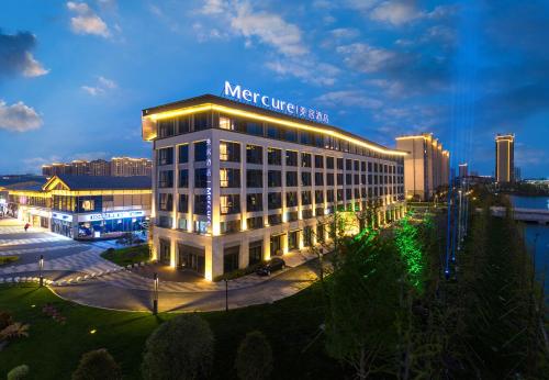 a large building with a sign on top of it at Mercure Jingjiang Downtown in Jingjiang