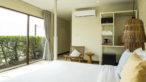 a bedroom with a bed and a large window at Sea Sun Bed & Beyond in Bang Rak Beach
