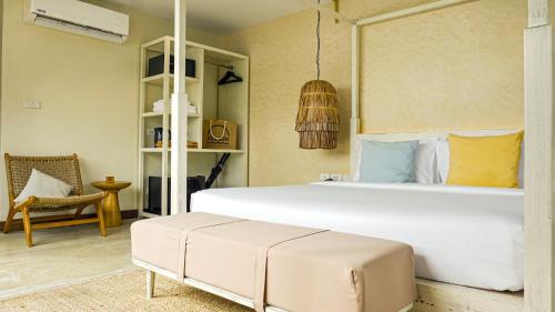 a bedroom with a large white bed and a chair at Sea Sun Bed & Beyond in Bang Rak Beach