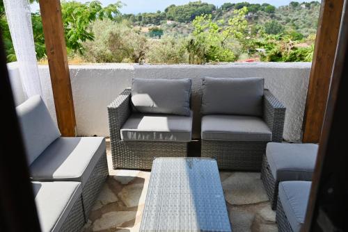 a patio with two chairs and a table on a balcony at Rastoni Apartments Skiathos in Troulos