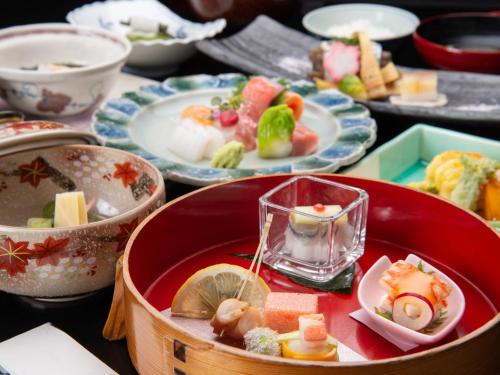 a table with plates of food and bowls of food at Kaihinsou Kamakura in Kamakura