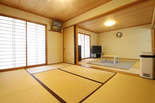 an empty room with large windows and a table at 別荘五岳 in Minami Aso
