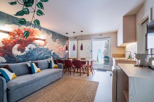 a living room with a couch and a painting of a wave at Chalet Lídia Lodges in Estoril