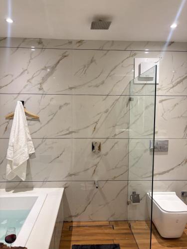 a bathroom with a shower and a toilet and a tub at Maple house Hillside 3-BHK Without Pvt Pool & Open Pizzeria in Kangra