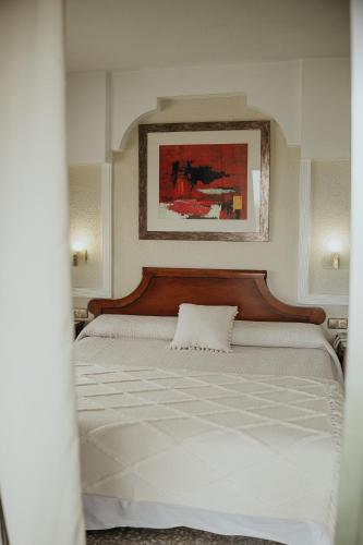 a bedroom with a large bed with a wooden headboard at Hotel Polamar in Santa Pola