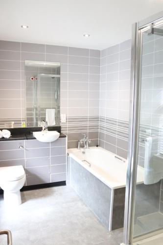 a bathroom with a tub and a toilet and a sink at Gwesty Seren Hotel in Blaenau-Ffestiniog
