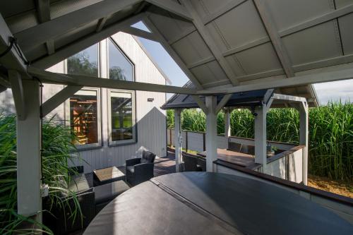 an outdoor patio with a table and a large window at Domek z jacuzzi na Folwarku Żuławskim in Elblag