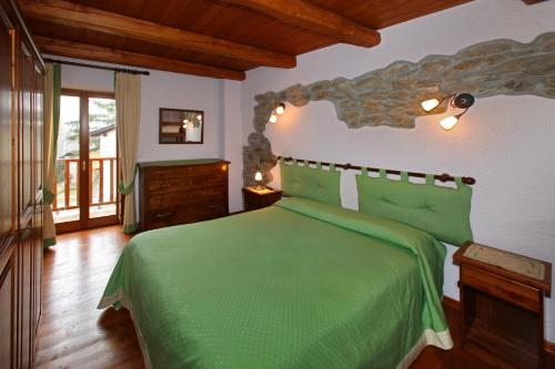 a bedroom with a green bed in a room at Casa Vacanze Elisa in Sauze dʼOulx