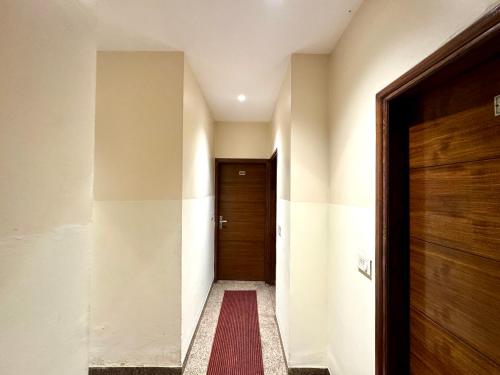 a hallway with a wooden door and a red rug at Hotel Bahl Regency in Zirakpur