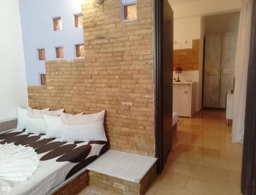 a bedroom with a brick wall and a bed with pillows at Samaya in Agigea