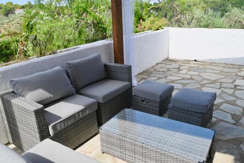 a patio with a couch and chairs and a table at Rastoni Apartments Skiathos in Troulos