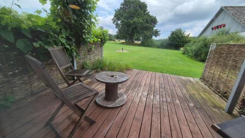 a wooden deck with two chairs and a table on it at Dalgården - ro og natur in Silkeborg