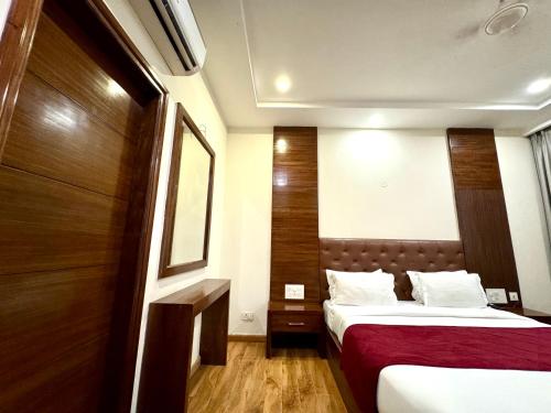a hotel room with two beds and a mirror at Hotel Bahl Regency in Zirakpur
