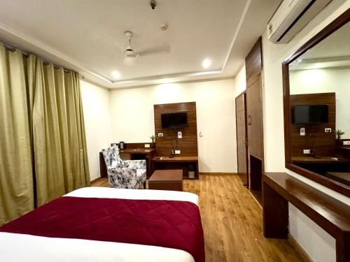 a hotel room with a bed and a desk at Hotel Bahl Regency in Zirakpur