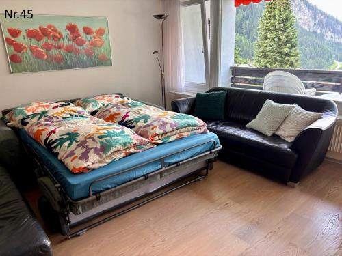 a bed and a couch in a living room at Apartments Haus Quelle in Leukerbad