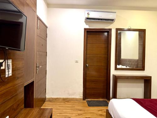 a bedroom with a bed and a television and a mirror at Hotel Bahl Regency in Zirakpur