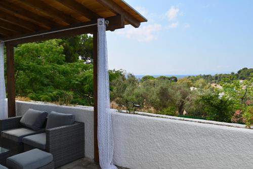 a balcony with a couch and a view of the ocean at Rastoni Apartments Skiathos in Troulos