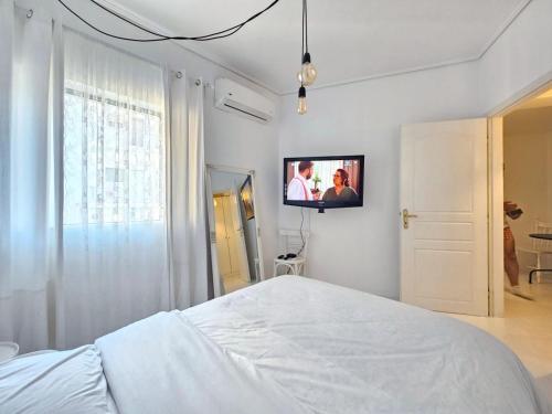 a bedroom with a bed and a tv on the wall at VK's Downtown Suite in Chalkida