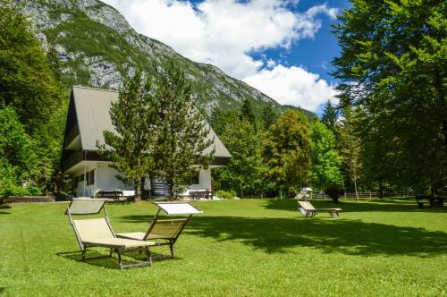 two chairs and a bench in the grass in front of a building at Vila Park B&B - Adults Only in Bohinj