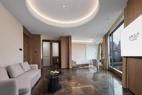 a living room with a couch and a table at Arula Mianyang Jianshan Hotel-绵阳见山檀程酒店 in Mianyang