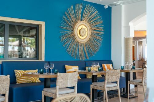 a dining room with blue walls and tables and chairs at Les Bulles de Mer - Hotel & Spa sur la Plage in Saint-Cyprien