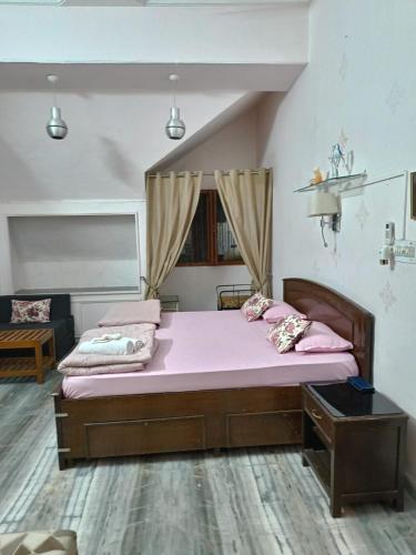 a bedroom with two beds with pink sheets at The Villa- a Home away from Home in Ajmer
