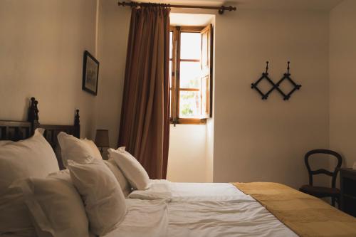 a bedroom with a bed with white pillows and a window at Finca Can Estades in Calvia Town